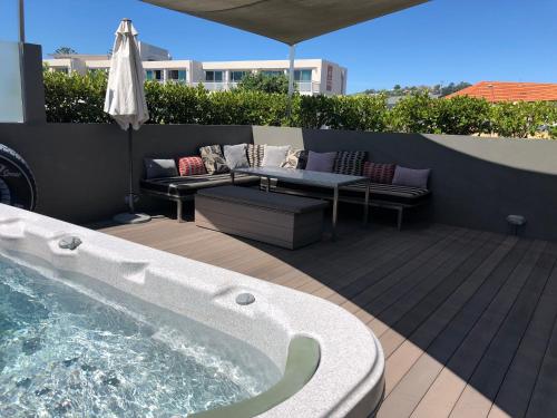 a patio with a hot tub and a couch and a table at Luxurious Loft Apartments in the heart of Ahuriri in Napier