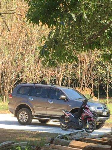 a motorcycle is parked next to a suv at Homebar in Ko Chang