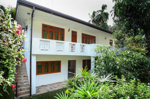 a white house with red doors and plants at 12 B 1/1, Lewella Rd, Kandy in Kandy