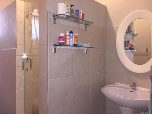a bathroom with a sink and a mirror at Atlantic Breeze Apartments, Canouan Island in Canouan