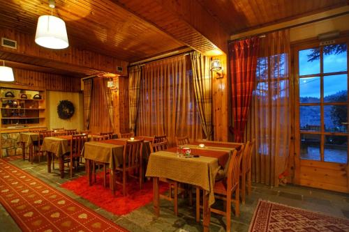 um restaurante com mesas e cadeiras e uma grande janela em Guesthouse Alexandra em Eptalofos