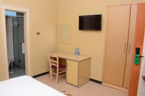 a room with a desk and a tv on the wall at Medal hotel in Addis Ababa