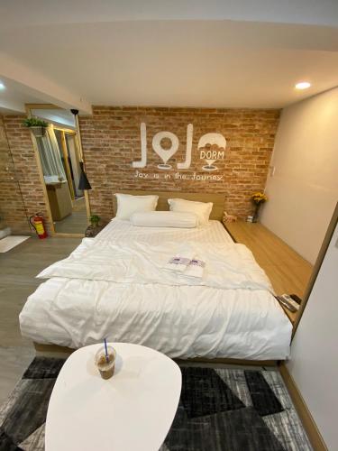 a large white bed in a room with a brick wall at jojoroom in Ho Chi Minh City