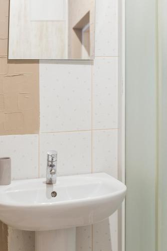a bathroom with a white sink and a mirror at Pigi nakvyne in Šiauliai