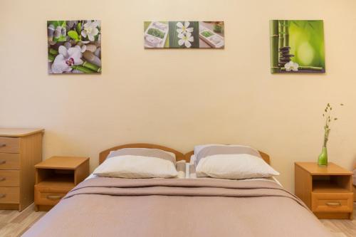 a bedroom with a bed and three pictures on the wall at Pigi nakvyne in Šiauliai