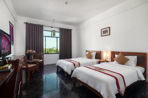 Postel nebo postele na pokoji v ubytování Kingdom Angkor Hotel
