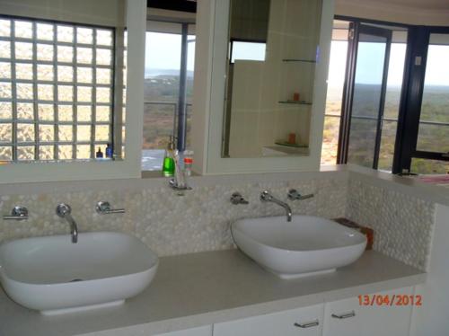 a bathroom with two sinks and two mirrors at Eco Haven retreat in Kalbarri