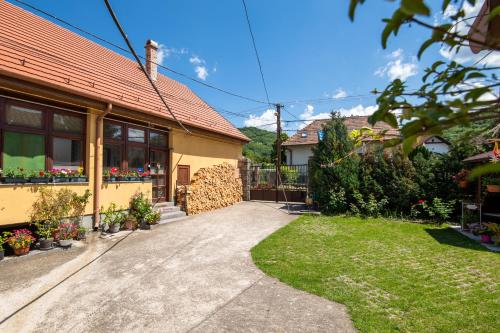 ein Haus mit einem Garten und einer Auffahrt in der Unterkunft Vogel Ági Vendégháza in Visegrád