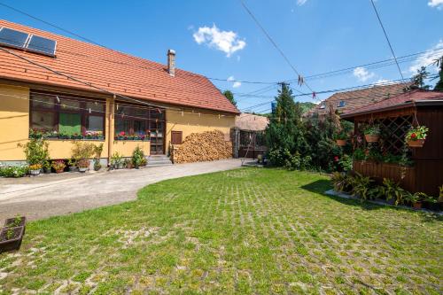 ein Haus mit einem Hof vor einem Gebäude in der Unterkunft Vogel Ági Vendégháza in Visegrád