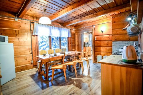 una sala da pranzo con tavolo e sedie in legno di Chata pod Bukiem 1 a Kościelisko