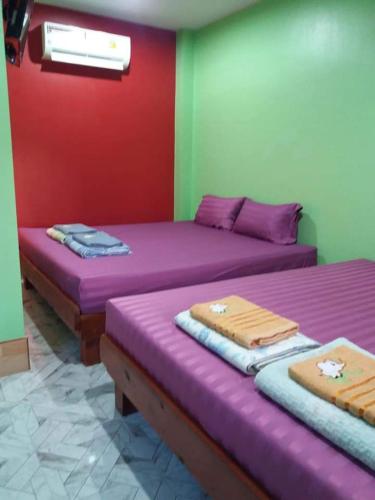 two beds in a room with purple and green walls at Yahle Villa เยห์เล่วิลล่า in Chao Lao Beach