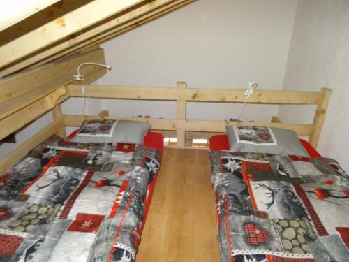 2 Einzelbetten in einem Zimmer mit Etagenbett in der Unterkunft Les Combles des Murailles in Champéry