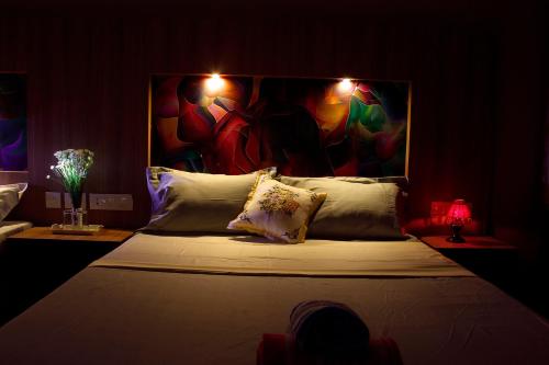 a bedroom with a bed with a painting on the wall at Hotel Skyark in Kanyakumari