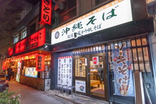 a store with signs on the side of a street at Living Inn Asahibashiekimae Premier in Naha