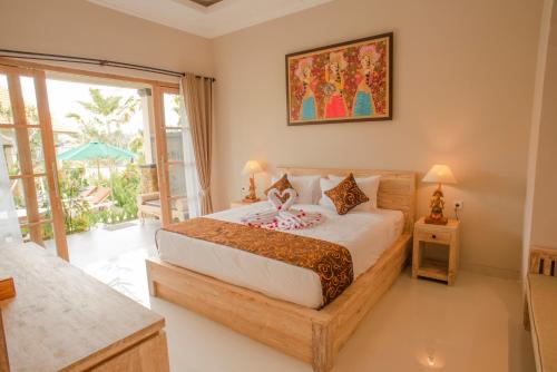 a bedroom with a bed and a large window at Auma Villa by Prasi in Ubud