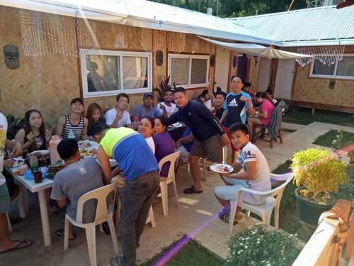 a group of people are sitting at a table at Mama Hostel & Guest House in El Nido