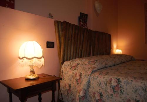 a bedroom with a bed and a lamp on a table at Agriturismo Villa Greggio in Casalserugo