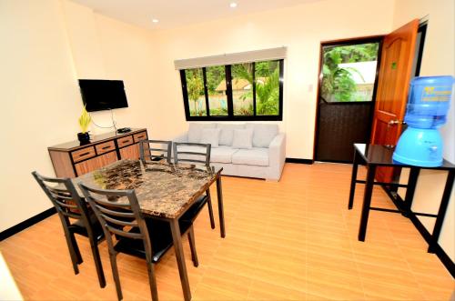 uma sala de estar com uma mesa e cadeiras e um sofá em Tatay Seseng's Apartment em Panglao