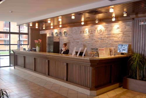 a woman sitting at a counter in a restaurant at Lion Bansko Hotel in Bansko