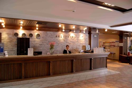 a woman standing at a bar in a restaurant at Lion Bansko Hotel in Bansko