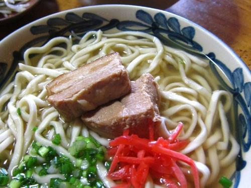 a bowl of noodles with meat and vegetables on a table at Living Inn Asahibashiekimae Premier in Naha