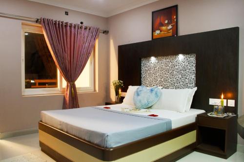 a bedroom with a large bed and a window at Hotel Skyark in Kanyakumari