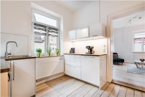 a kitchen with white cabinets and a window at #1 AUGSBURG Altstadtjuwel in Augsburg