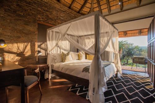 a bedroom with a bed with a canopy at Tala Collection Game Reserve in Silverton
