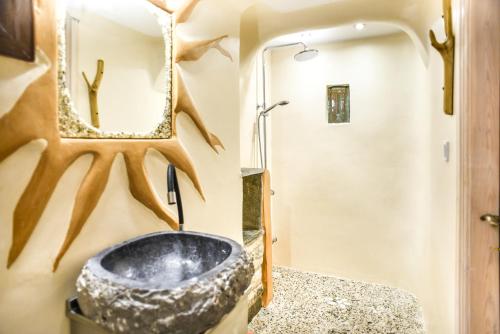 a bathroom with a stone sink and a mirror at Victoria's Country Apartments in Zagora