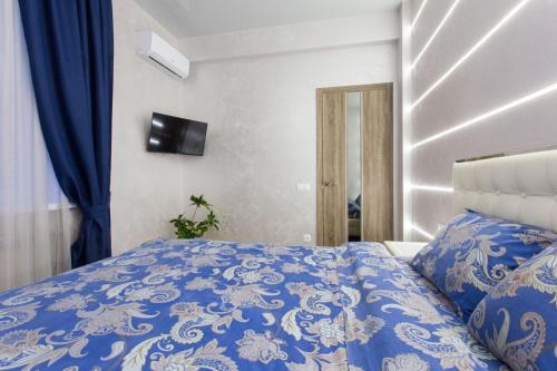 a bedroom with a bed with a blue comforter at New luxury Apartment in the Center on Konstitution Square in Kharkiv