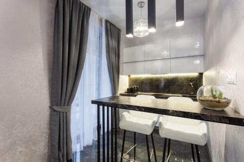a bathroom with a counter with a sink and white chairs at New luxury Apartment in the Center on Konstitution Square in Kharkiv