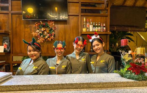 quatre femmes avec des bois sur la tête debout derrière un comptoir dans l'établissement Kusnadi Hotel, à Legian