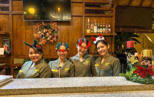 four women with antlers on their heads standing behind a counter at Kusnadi Hotel in Legian