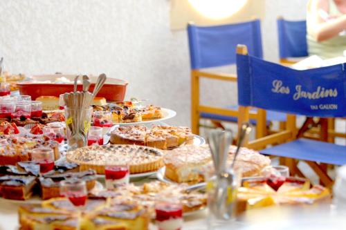 a table filled with pies and desserts on plates at Le Galion Hotel et Restaurant Canet Plage - Logis in Canet-en-Roussillon
