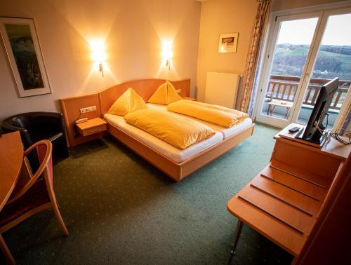 a bedroom with a bed and a television and a balcony at eckbergerhof in Gamlitz