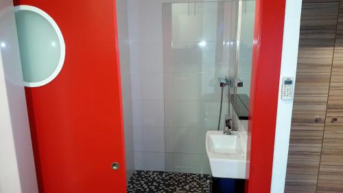 ロザスにあるGlobal Immo 1035 Sol Levanteの赤いドアとトイレ付きのバスルーム