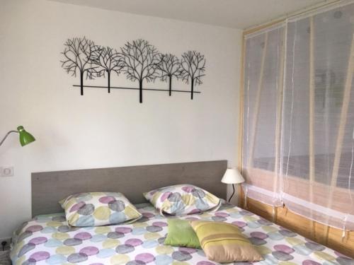 Schlafzimmer mit einem Bett mit Bäumen an der Wand in der Unterkunft Les Jardins du Golf in Metz