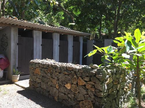a stone retaining wall in front of a fence at Hidden Well Hiriketiya in Hiriketiya