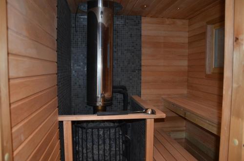uma sauna com um aquecedor num camarote de madeira em Kainiemen Huvilat em Nurmes