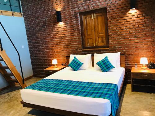 a bedroom with a large bed in a brick wall at Eliyanth Udawalawe in Udawalawe