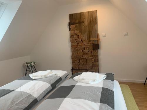two beds in a room with a brick wall at Mariazeller Rooms in Mariazell