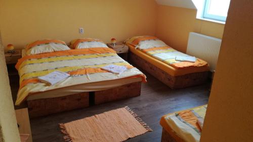 a room with three beds in a room at Penzión Ranč Šenkvice in Veľké Čaníkovce