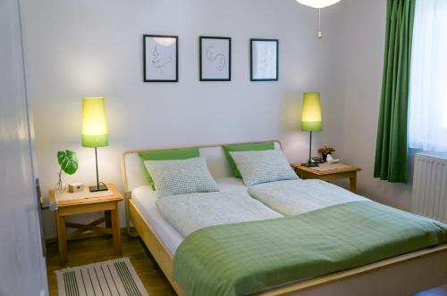 a bedroom with a bed with two lamps on two tables at Toldi68 Apartmanház in Keszthely