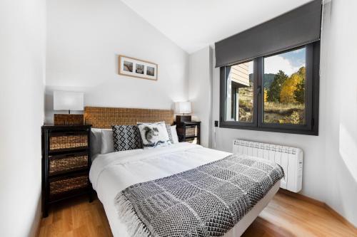 Un dormitorio con una cama grande y una ventana en Apartaments El Floc, en El Tarter