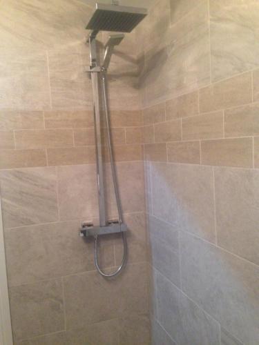 a shower with a shower head in a bathroom at Cauldwell Villas in South Shields