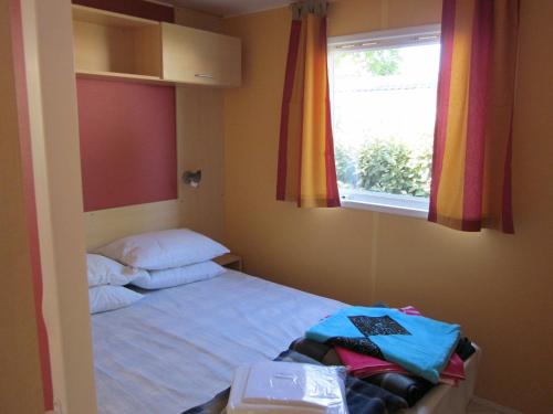 a small bedroom with a bed and a window at Richards Holidays in Jard-sur-Mer