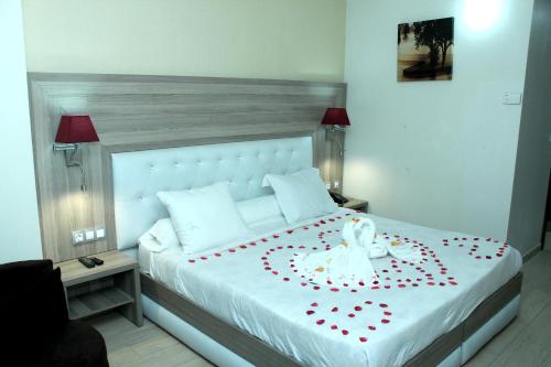 a bedroom with a bed with a flower on it at HOTEL AMSTERDAM in Rouiba