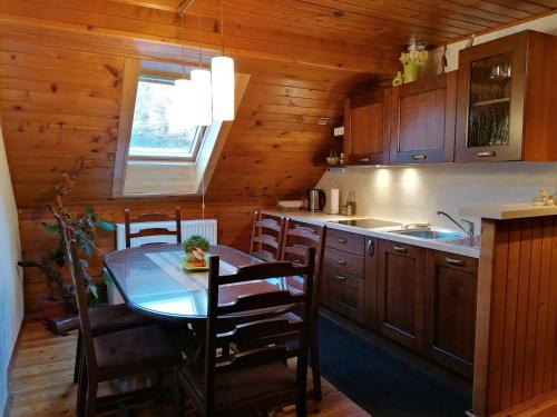 a kitchen with a table and chairs in a cabin at Apartment Sotočje in Dolenja Trebuša