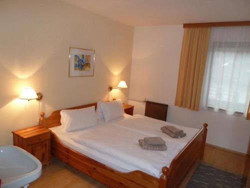 a bedroom with a large bed and a sink at Appartement Hauser in Stumm