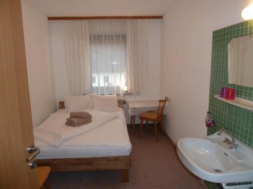 a small room with a bed and a sink at Appartement Hauser in Stumm